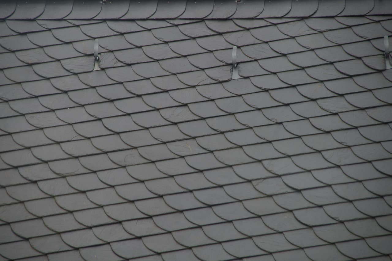 Rows of new grey slates on a freshly finished roof