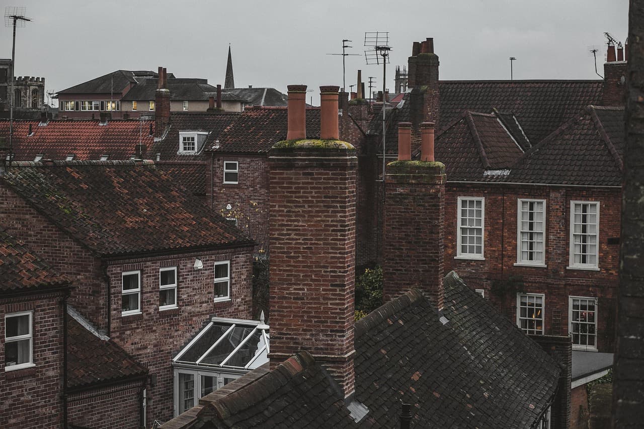 Brick chimney stacks and slate roofs across an English town